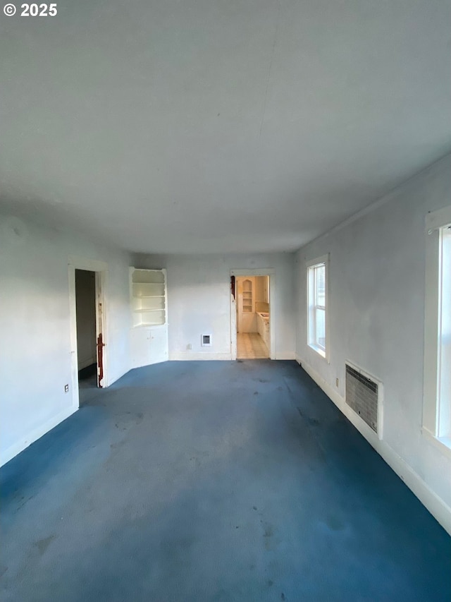 1412 5th St, Tillamook, OR 97141 - unfurnished living room with heating unit, carpet flooring, visible vents, and baseboards