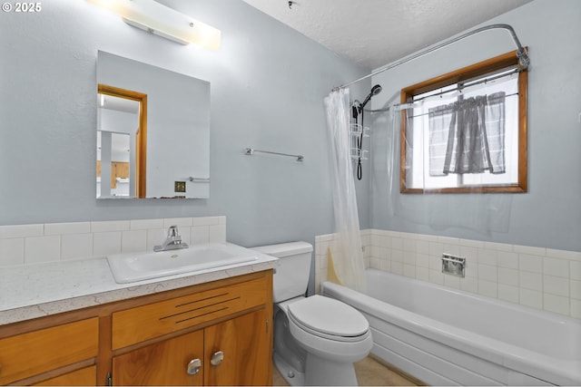 bathroom with toilet, vanity, shower / tub combo, and a textured ceiling