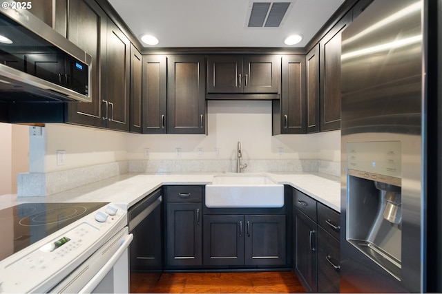 7501 NE 51st Way, Vancouver, WA 98662 - kitchen featuring stainless steel appliances, a sink, dark wood-style floors, dark brown cabinetry, and recessed lighting