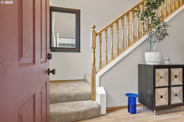 staircase with baseboards and wood finished floors