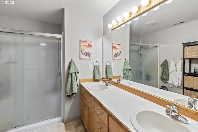 full bathroom featuring visible vents, a sink, double vanity, and a shower stall