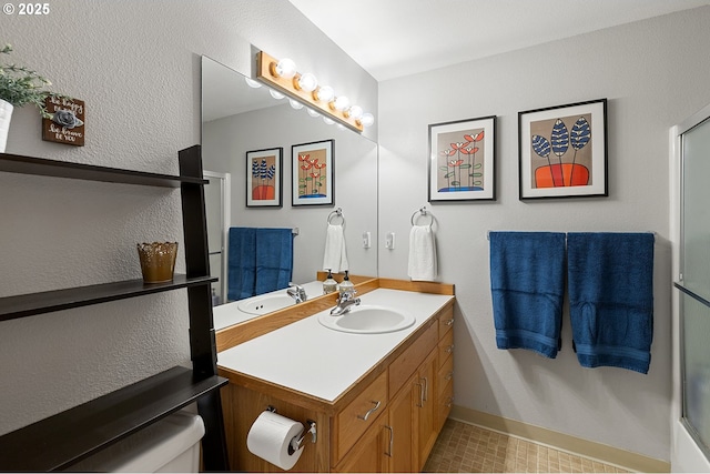 full bathroom featuring vanity, a shower with door, baseboards, and toilet