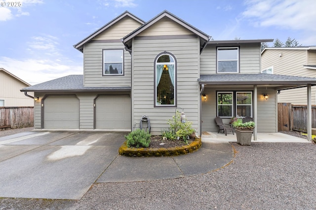 traditional-style home featuring a garage, fence, driveway, and a shingled roof
