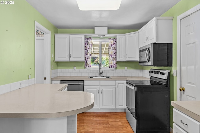 2386 Clear Vue Ln, Springfield, OR 97477 - kitchen featuring stainless steel appliances, a sink, light countertops, white cabinetry, and light wood finished floors