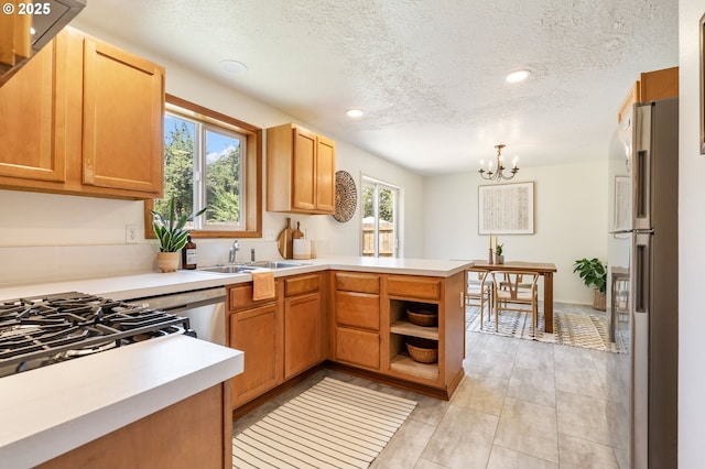 6837 SE 84th Ave, Portland, OR 97266 - kitchen featuring freestanding refrigerator, a peninsula, plenty of natural light, a textured ceiling, and a chandelier
