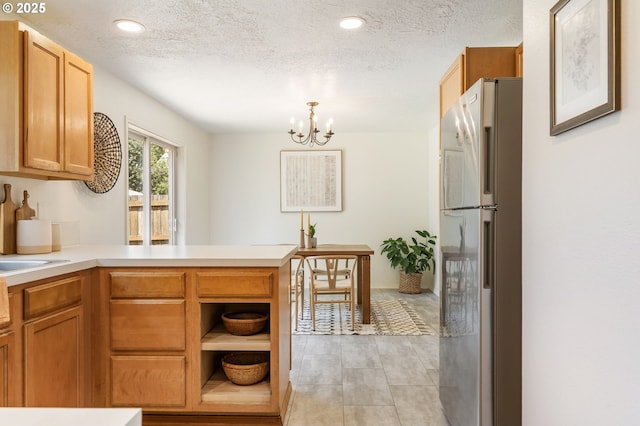 6837 SE 84th Ave, Portland, OR 97266 - kitchen featuring refrigerator, a peninsula, a chandelier, light countertops, and a textured ceiling