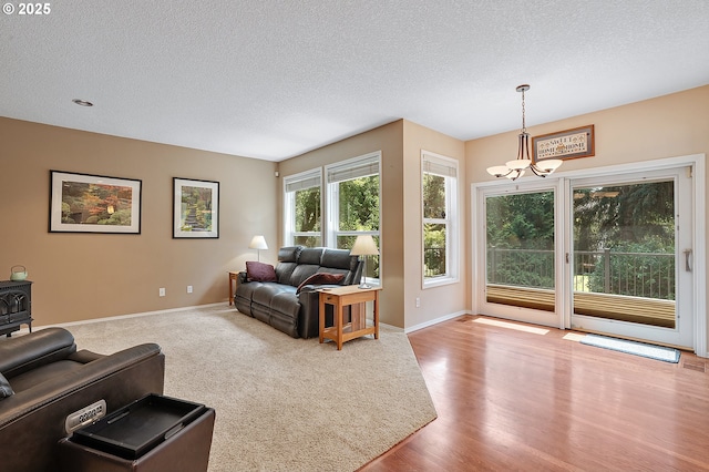 4710 SW Joshua St, Tualatin, OR 97062 - living room featuring a chandelier, a textured ceiling, a wood stove, and wood finished floors