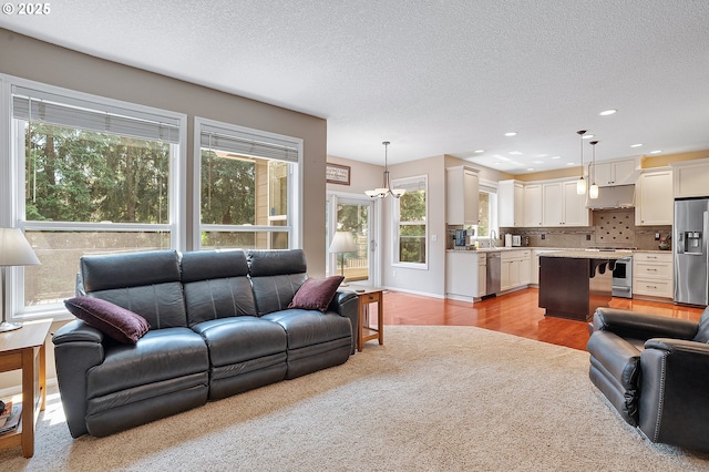 4710 SW Joshua St, Tualatin, OR 97062 - living room featuring a textured ceiling, recessed lighting, light wood finished floors, and a chandelier