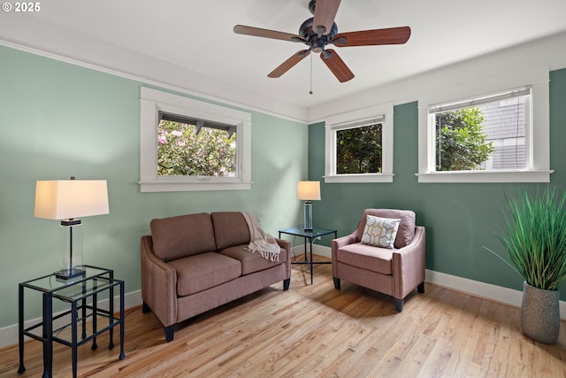 sitting room featuring healthy amount of natural light, baseboards, a ceiling fan, and wood finished floors