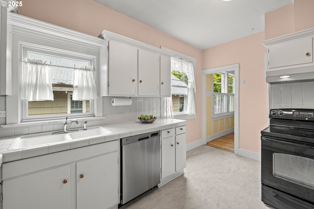 kitchen featuring black / electric stove, dishwasher, tile counters, under cabinet range hood, and a sink