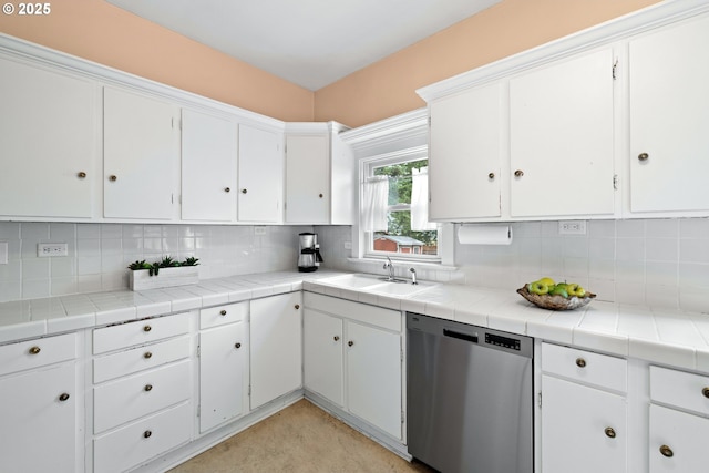 kitchen featuring stainless steel dishwasher, a sink, and white cabinets
