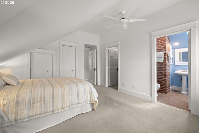 bedroom with lofted ceiling, carpet floors, a sink, baseboards, and ceiling fan