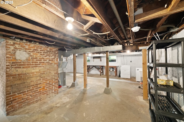 below grade area featuring washer and dryer and brick wall
