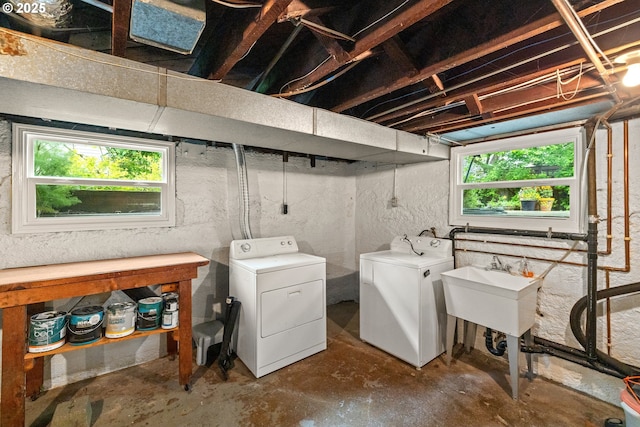 clothes washing area with washer and dryer and healthy amount of natural light