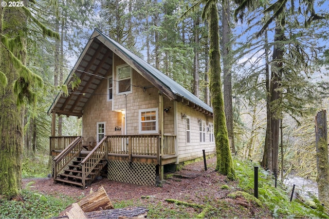 rear view of property featuring metal roof and a wooden deck