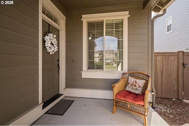 doorway to property with covered porch and fence