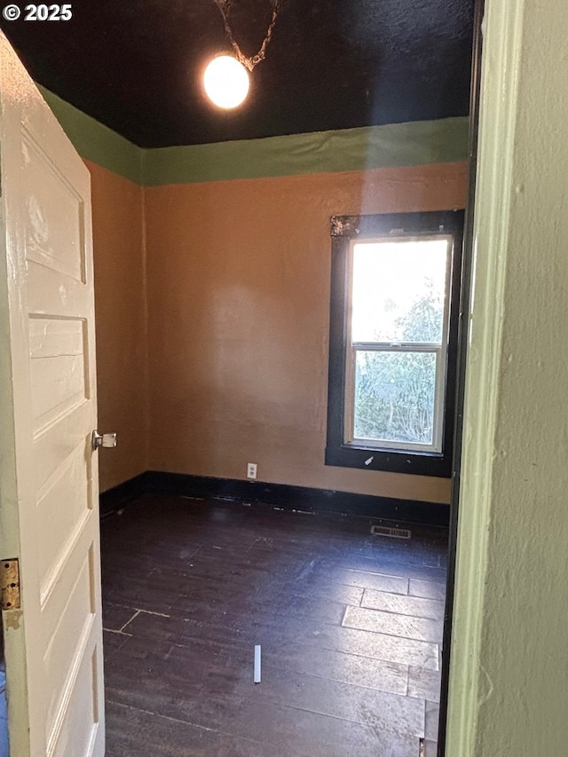 spare room with visible vents and dark wood-type flooring