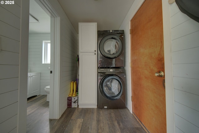 92700 Holly Ln, Astoria, OR 97103 - clothes washing area featuring stacked washer and clothes dryer and dark wood-type flooring
