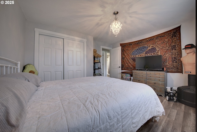 92700 Holly Ln, Astoria, OR 97103 - bedroom with wood finished floors, a closet, and a chandelier