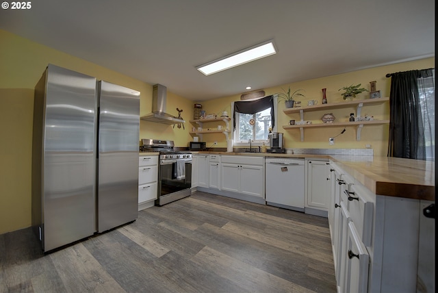 92700 Holly Ln, Astoria, OR 97103 - kitchen featuring appliances with stainless steel finishes, open shelves, wall chimney range hood, dark wood-style flooring, and white cabinets