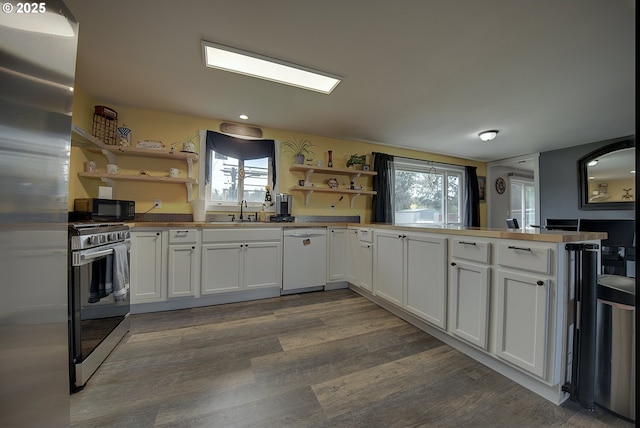 92700 Holly Ln, Astoria, OR 97103 - kitchen with stainless steel appliances, open shelves, a sink, dark wood-style floors, and recessed lighting