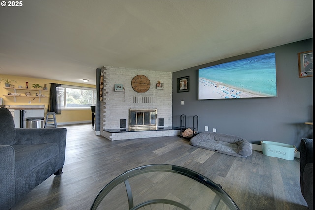 92700 Holly Ln, Astoria, OR 97103 - living area with a brick fireplace, wood finished floors, and baseboards