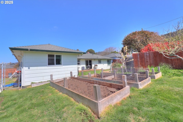 94178 9th St, Gold Beach, OR 97444 - back of property with a vegetable garden and a shingled roof