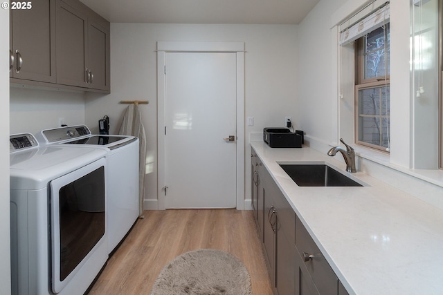 60486 Seventh Mountain Dr, Bend, OR 97702 - clothes washing area with light wood-style floors, washer and clothes dryer, a sink, and cabinet space