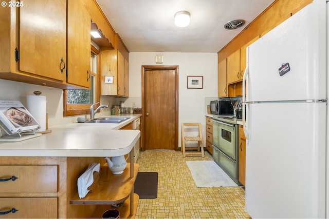 kitchen with visible vents, range with electric cooktop, black microwave, light countertops, and freestanding refrigerator