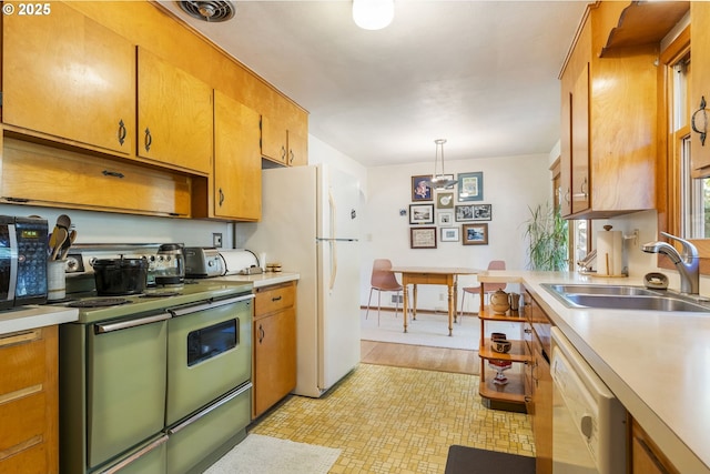 kitchen featuring a sink, decorative light fixtures, under cabinet range hood, white appliances, and light countertops