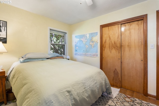 bedroom with a closet, a ceiling fan, and light wood finished floors