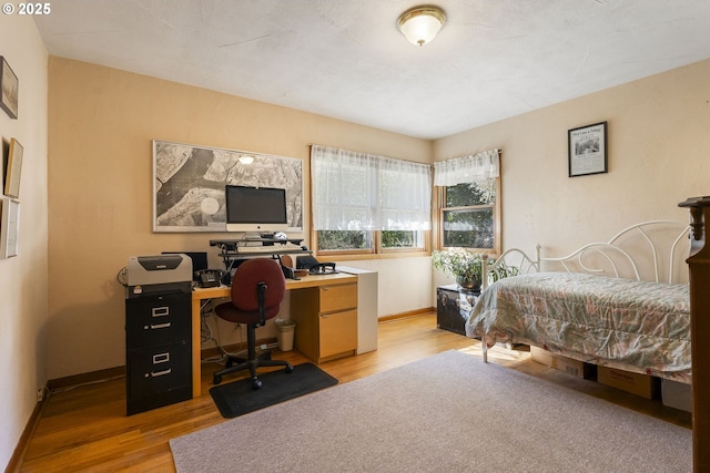 bedroom with baseboards and light wood-style flooring