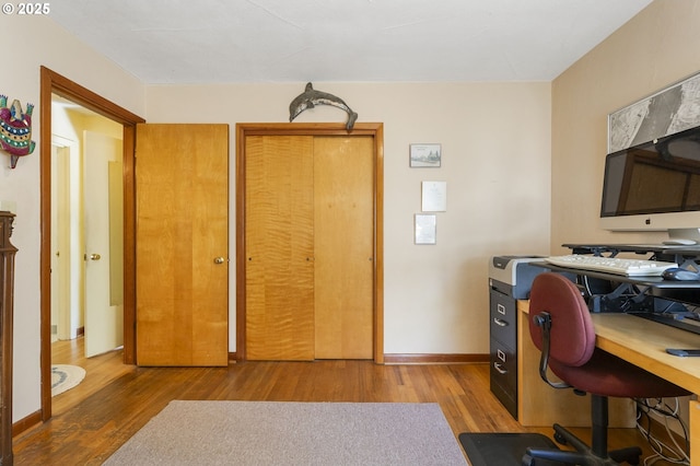 office space featuring baseboards and wood finished floors