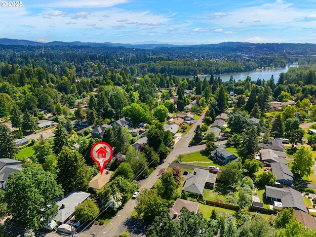 aerial view featuring a view of trees, a water view, and a residential view