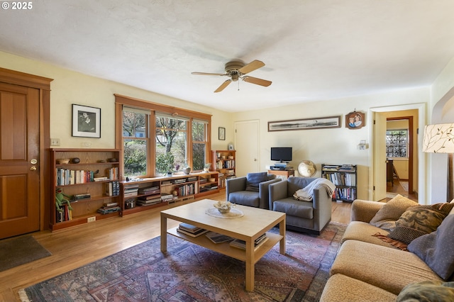 living room with wood finished floors and ceiling fan