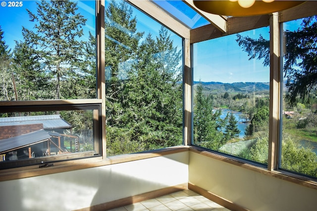 395 Rio Nes Ln, Roseburg, OR 97470 - unfurnished sunroom featuring tile patterned flooring, a mountain view, a skylight, and healthy amount of natural light