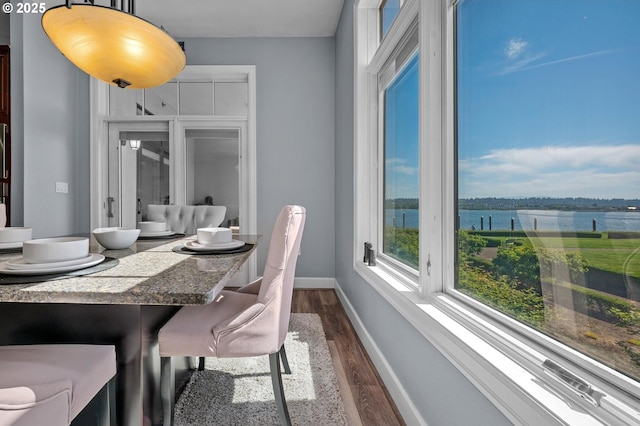 707 N Hayden Island Dr Unit 217, Portland, OR 97217 - dining room featuring dark wood-style flooring and a water view