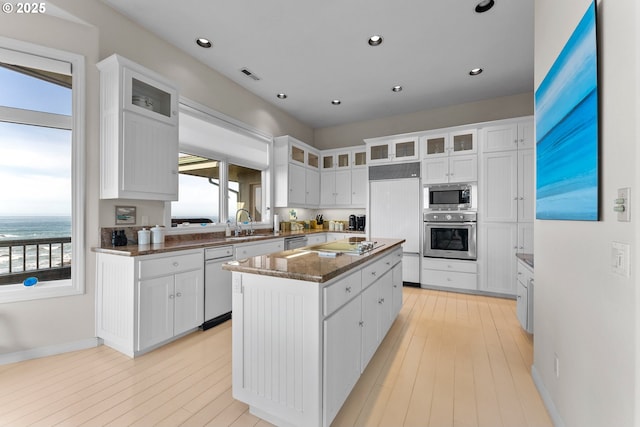 kitchen with a kitchen island, glass insert cabinets, and white cabinetry