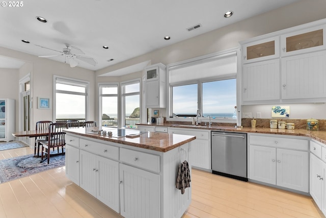 kitchen featuring black stovetop, white cabinetry, a sink, and stainless steel dishwasher