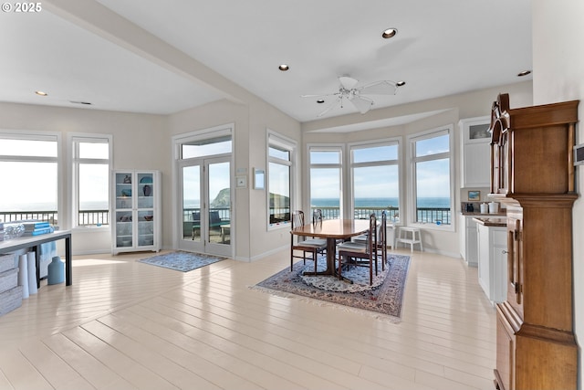 dining space featuring a wealth of natural light, a water view, and light wood finished floors