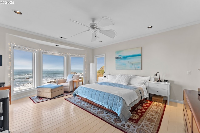 bedroom with a water view, a ceiling fan, baseboards, light wood finished floors, and crown molding