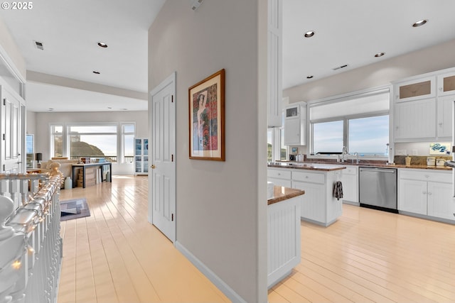 kitchen featuring glass insert cabinets, white cabinets, dishwasher, and light wood finished floors