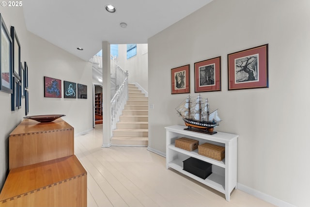 stairs with baseboards, wood finished floors, and recessed lighting