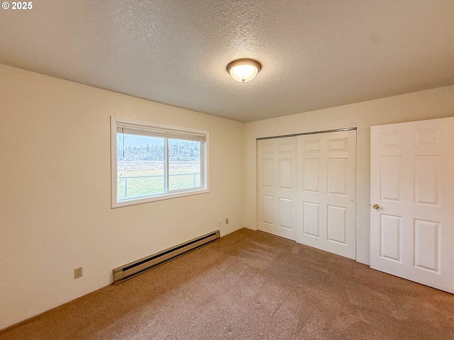 1883 Green Ave, Roseburg, OR 97471 - unfurnished bedroom with a baseboard heating unit, carpet floors, a textured ceiling, and a closet