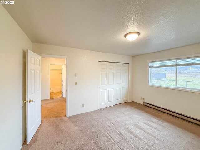 1883 Green Ave, Roseburg, OR 97471 - unfurnished bedroom featuring carpet floors, a baseboard heating unit, a closet, and a textured ceiling