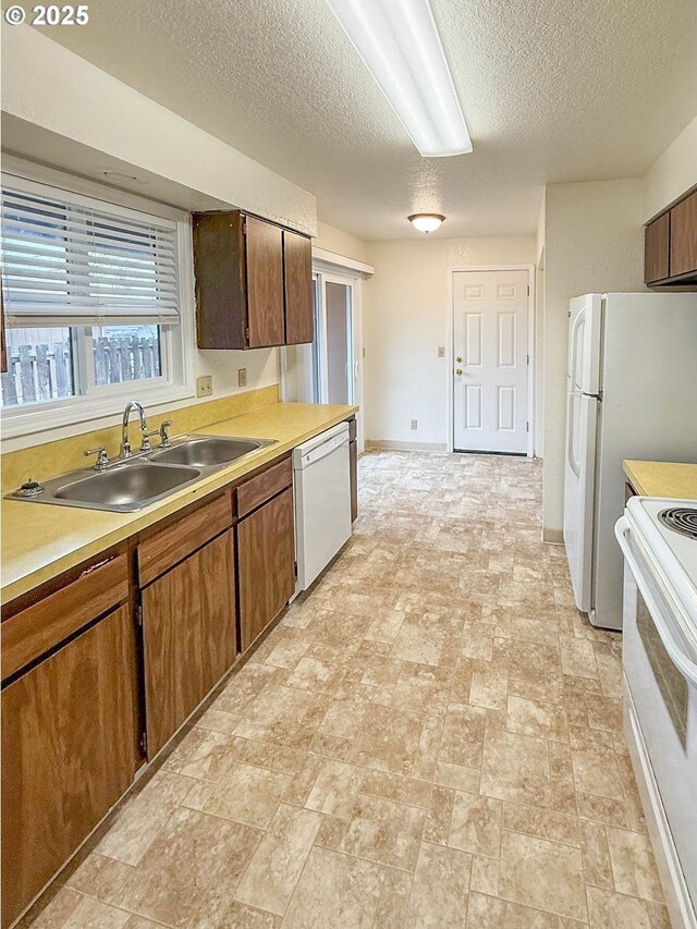 1883 Green Ave, Roseburg, OR 97471 - kitchen featuring white appliances, a sink, a textured ceiling, light countertops, and baseboards