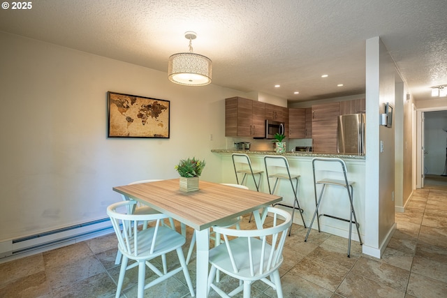 dining space with recessed lighting, a textured ceiling, baseboards, and a baseboard radiator