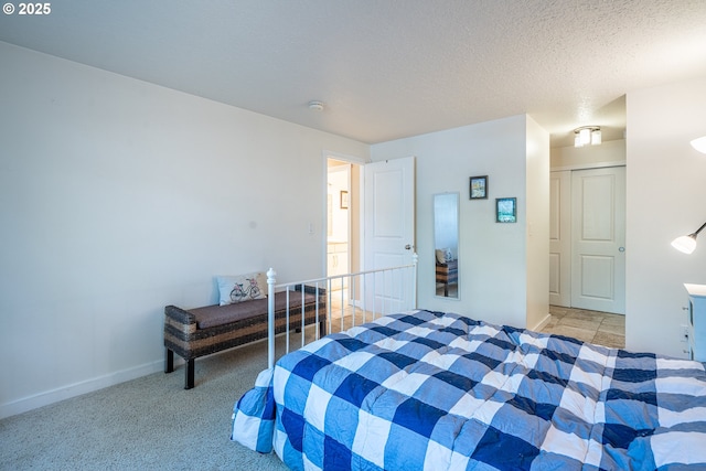bedroom featuring baseboards, light carpet, and a textured ceiling