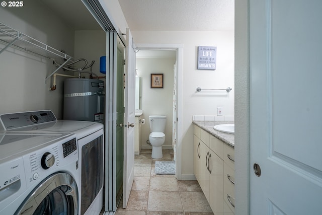 bathroom with vanity, toilet, baseboards, washing machine and clothes dryer, and water heater