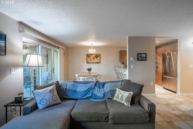 living area with baseboards and a textured ceiling